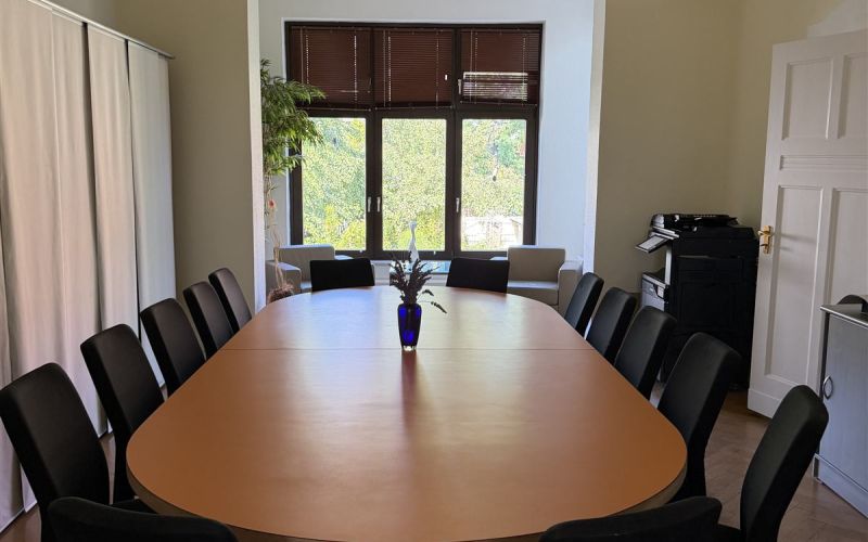 Besprechungsraum mit großem Konferenztisch im Altbau
